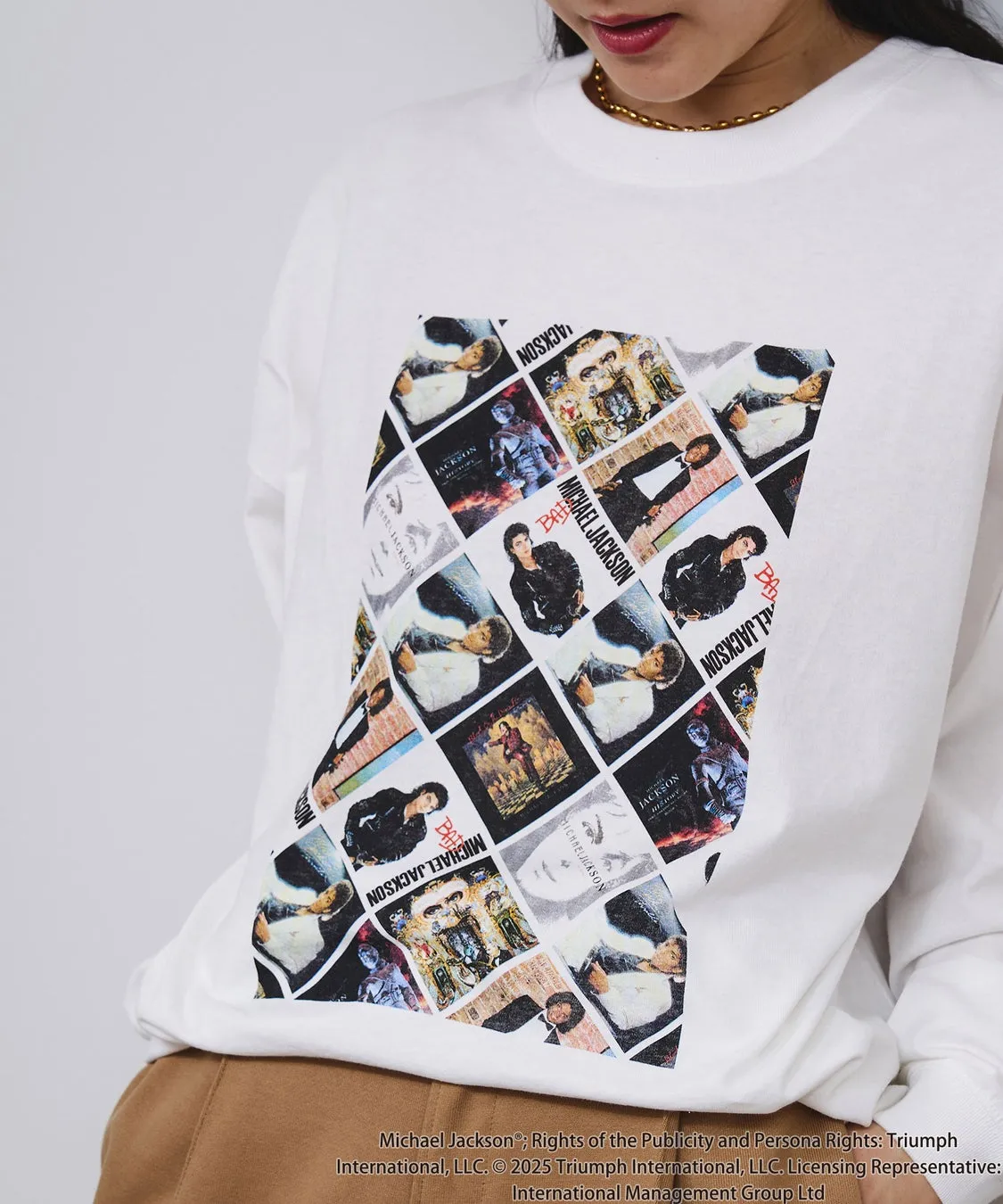 白いトレーナーを着た女性が、マイケル・ジャクソンをモチーフにしたデザインの服を着ている写真です。