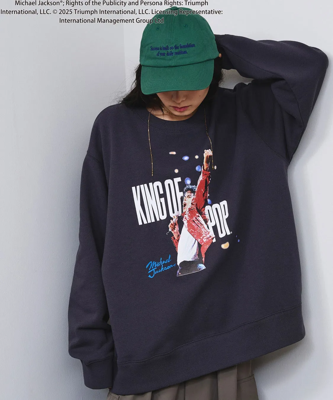 マイケル・ジャクソンのプリントが施された紺色のトレーナーを着た女性の写真。