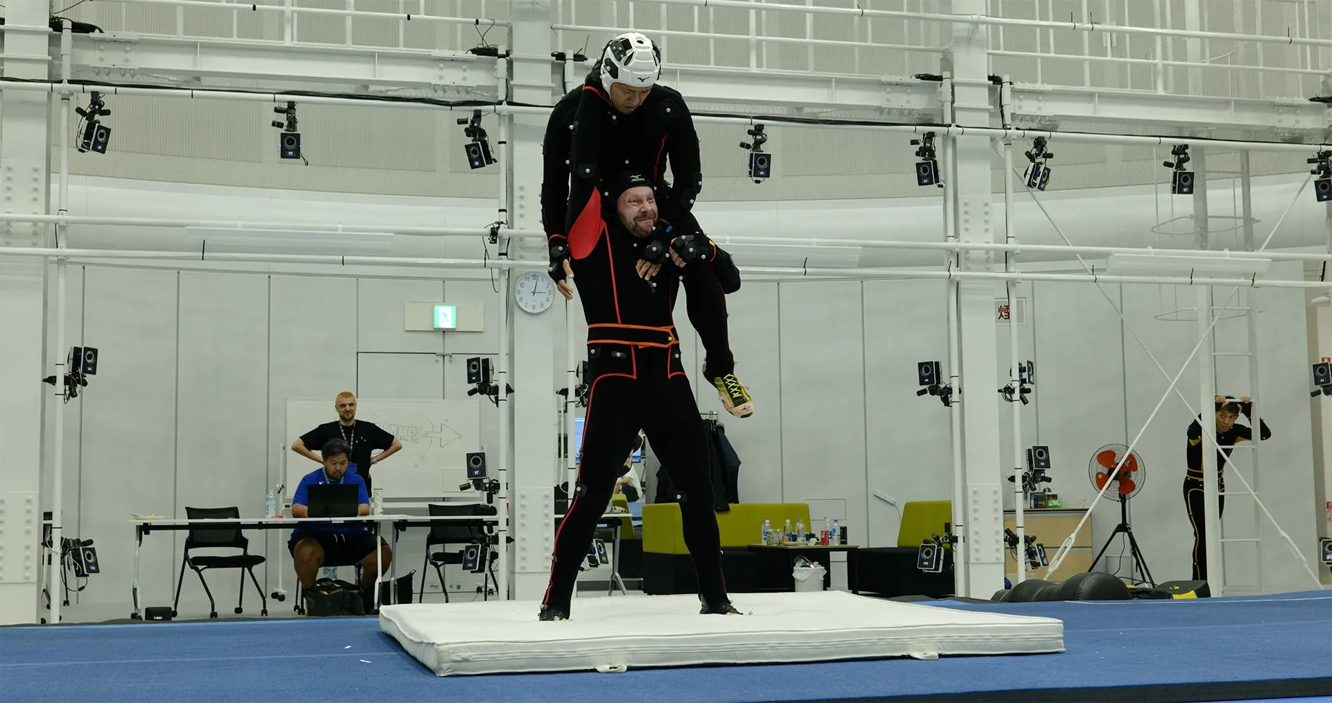 モーションキャプチャースタジオで、2人の男性がモーションキャプチャースーツを着てポーズ