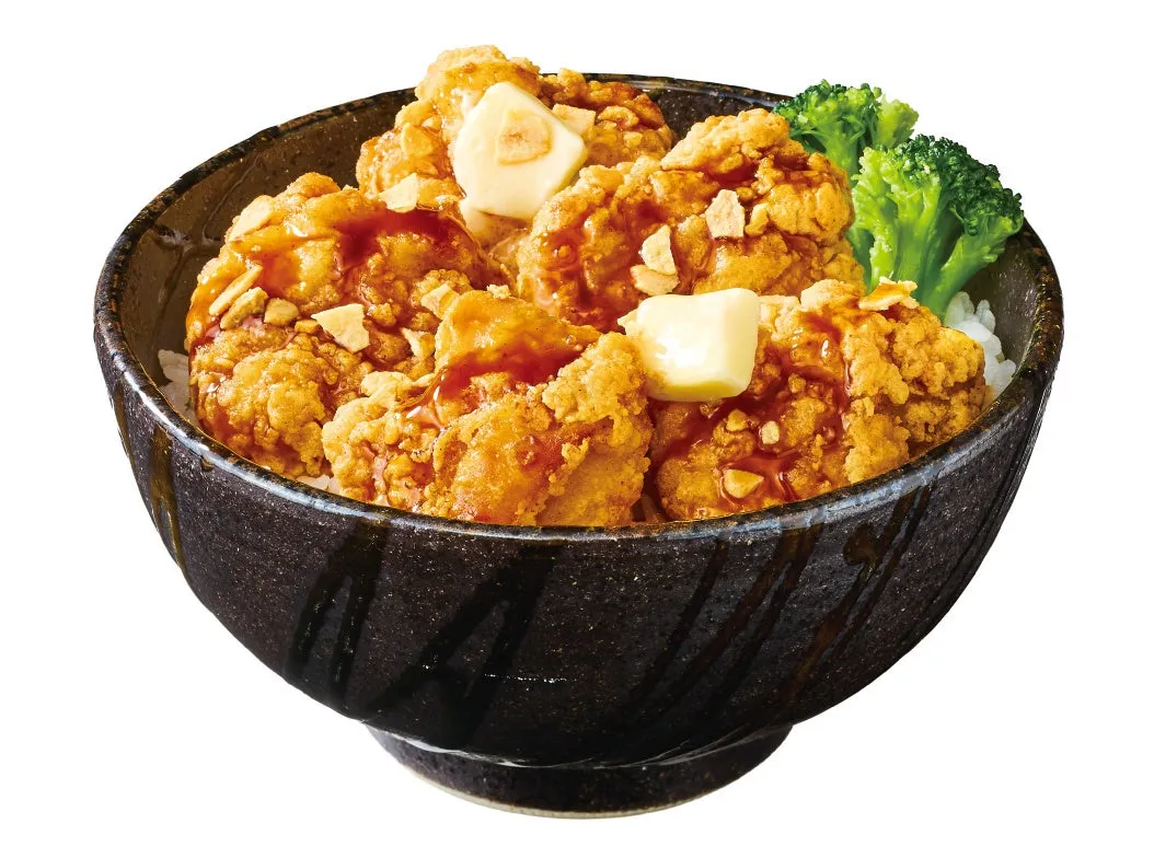 茶碗に盛られた鶏の唐揚げ丼の画像です。唐揚げにはバターとソースがかかっています。付け合わせにはブロッコリーが添えられています。