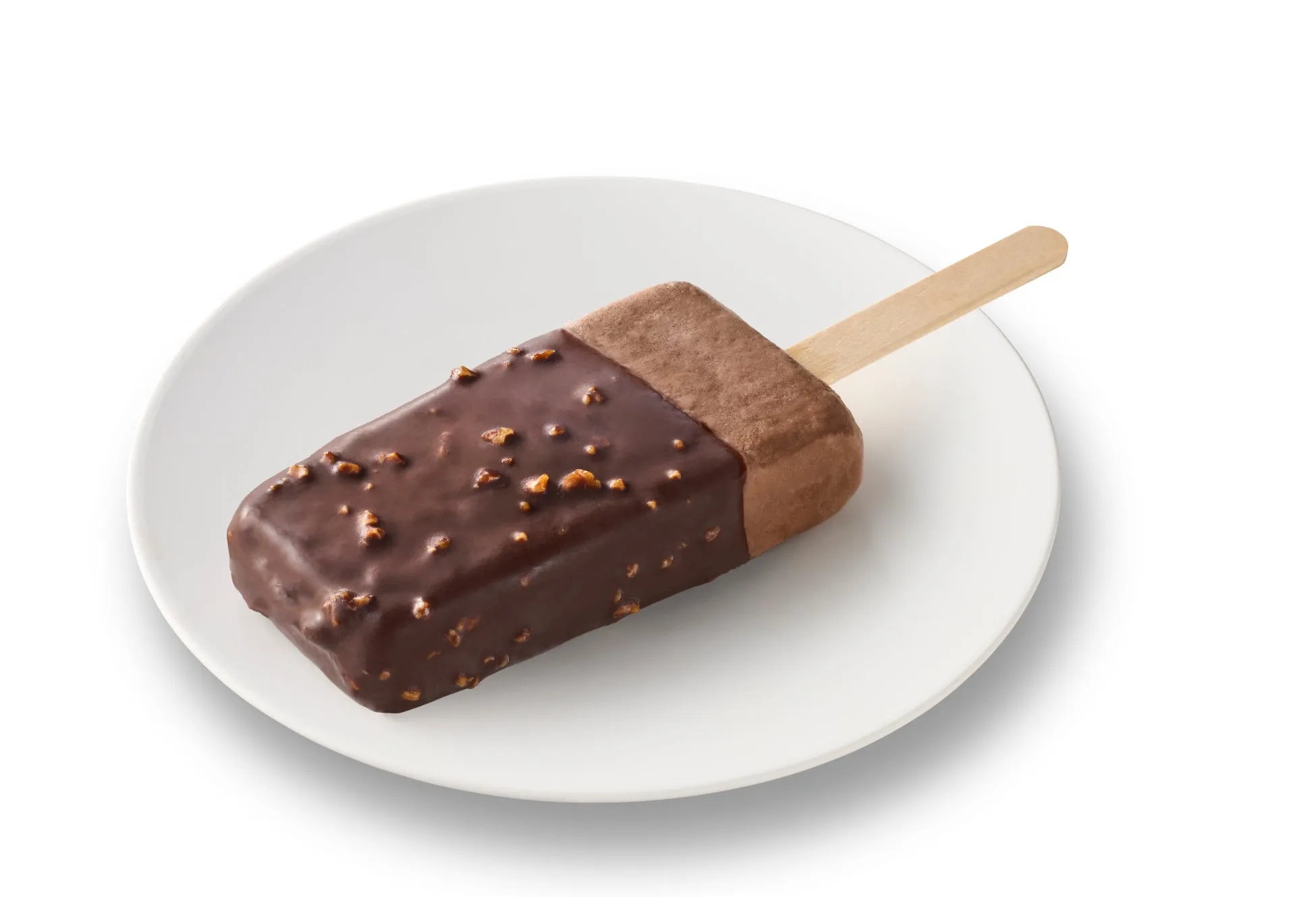 チョコレートでコーティングされたアイスキャンディーが白い皿の上に置かれている写真です。アイスキャンディーは茶色で、ナッツがトッピングされています。背景は白です。