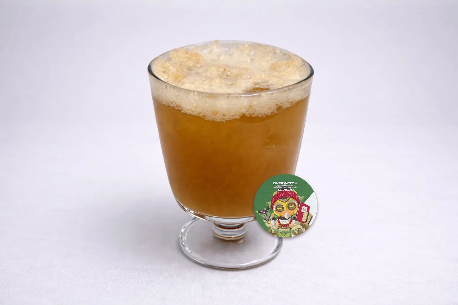 グラスに入った、泡のある琥珀色の飲み物