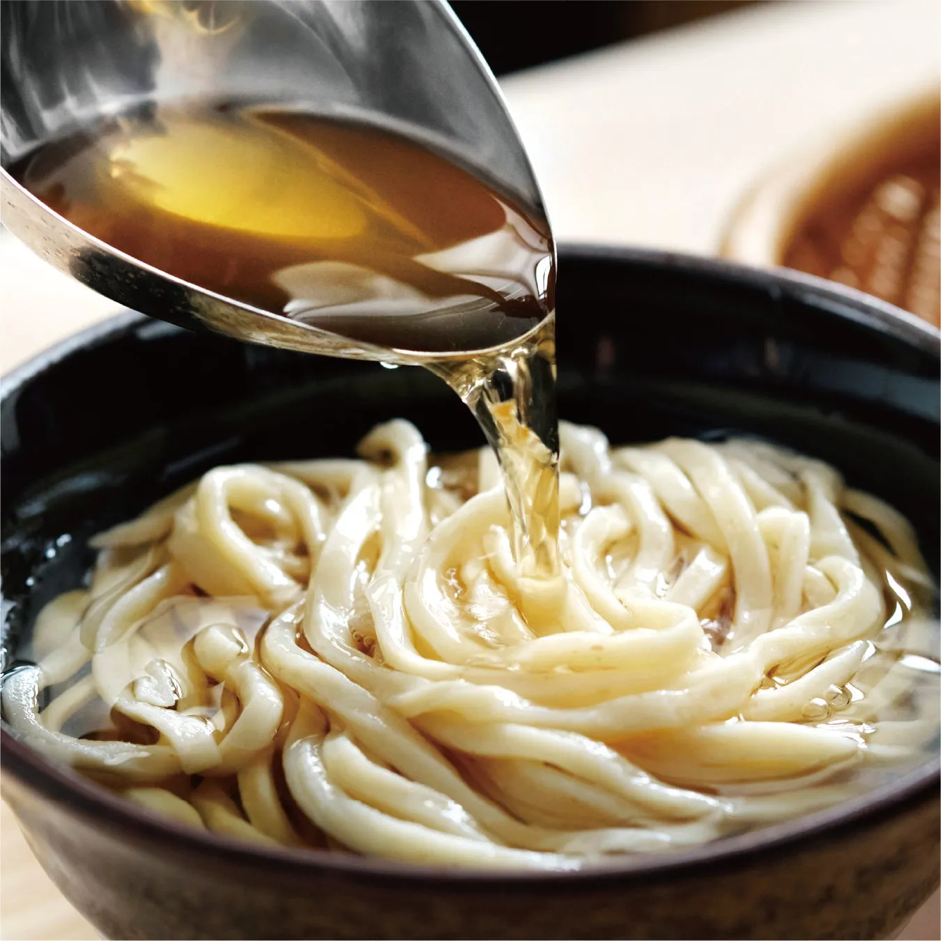 うどんのスープを注いでいる様子。