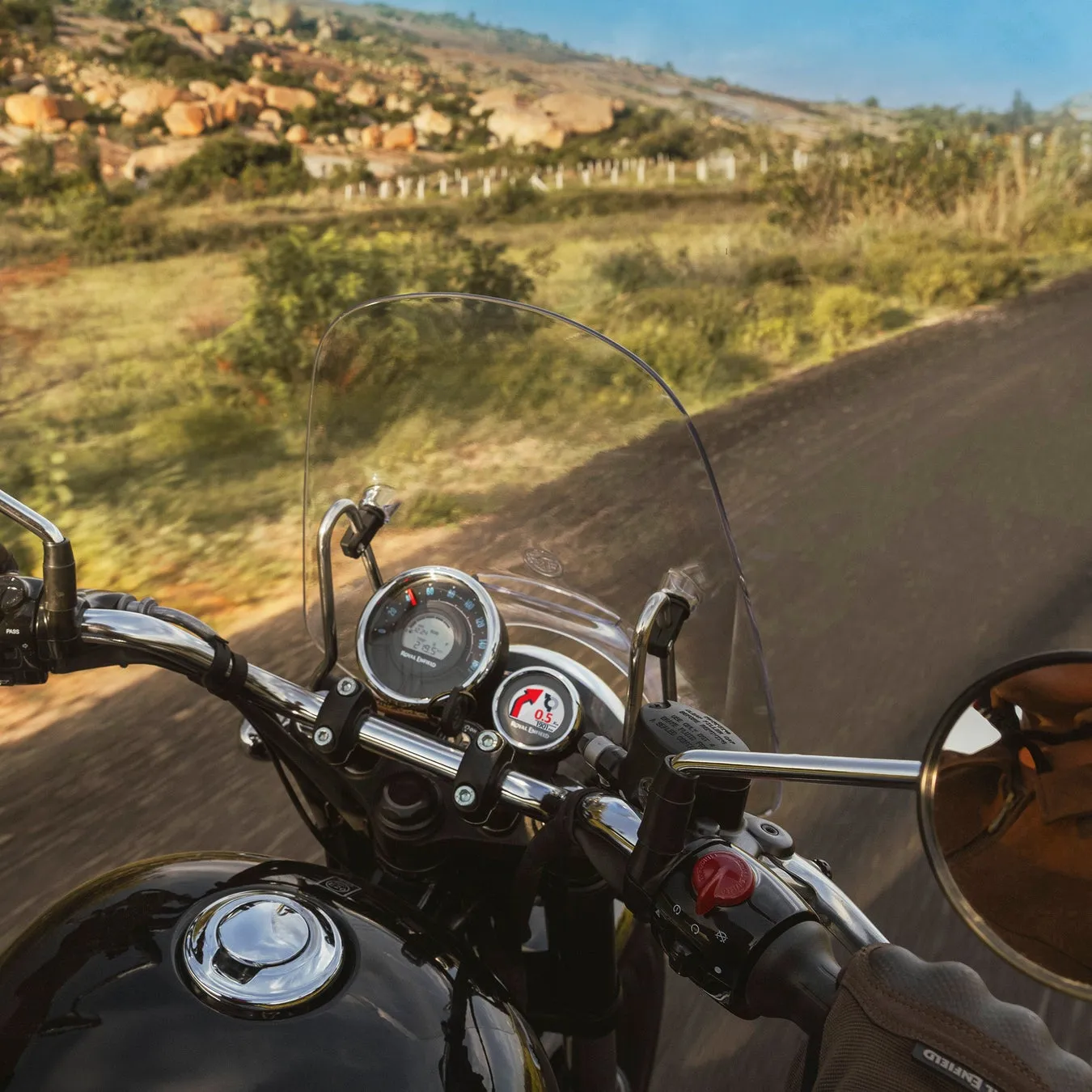 メーター、ハンドル、ミラーが写るバイクの運転席からの風景