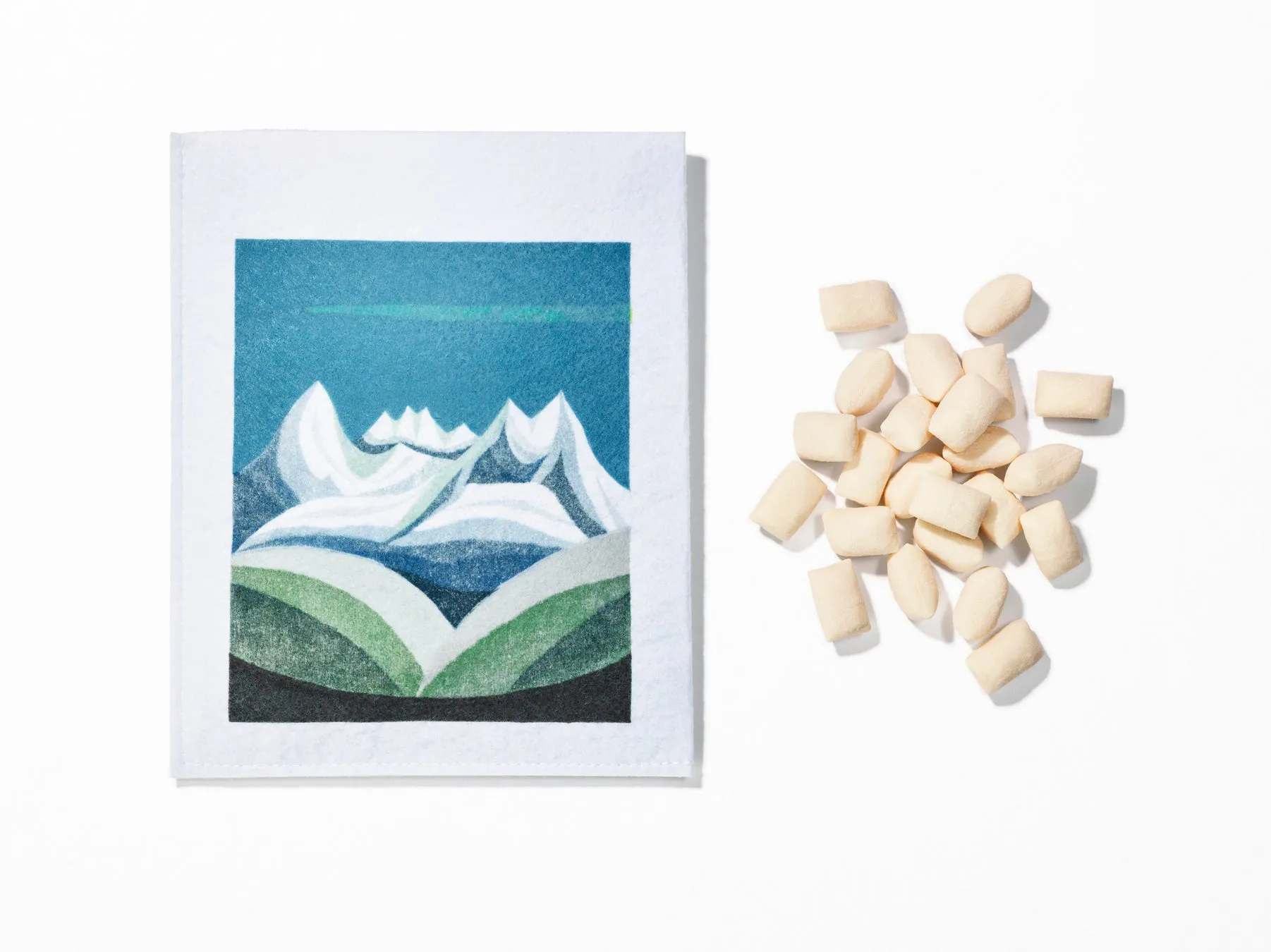 白い背景に、山の絵が描かれた小さな布と、ガムの塊
