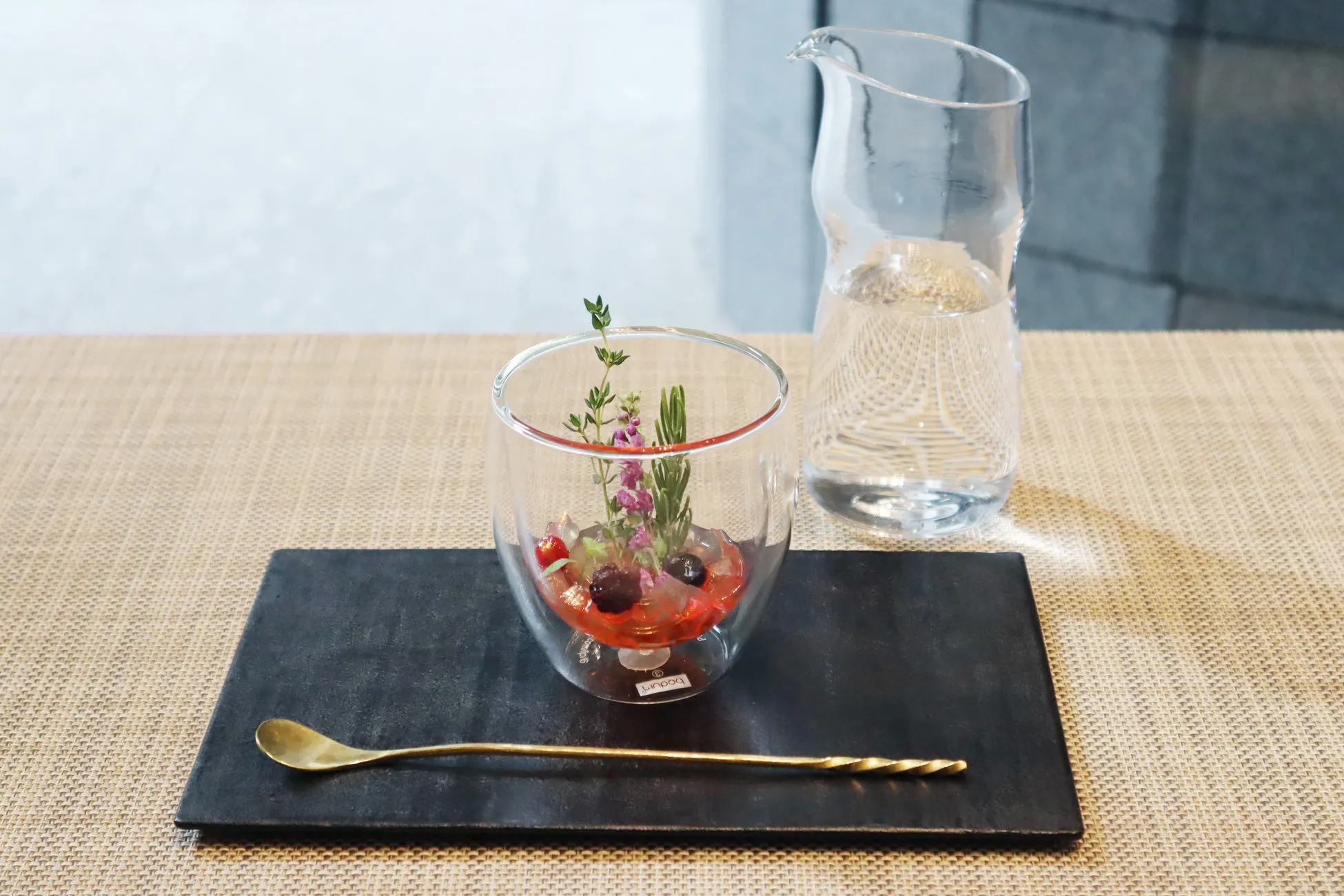 ガラスの器に入ったゼリーとハーブ、ベリーのデザート