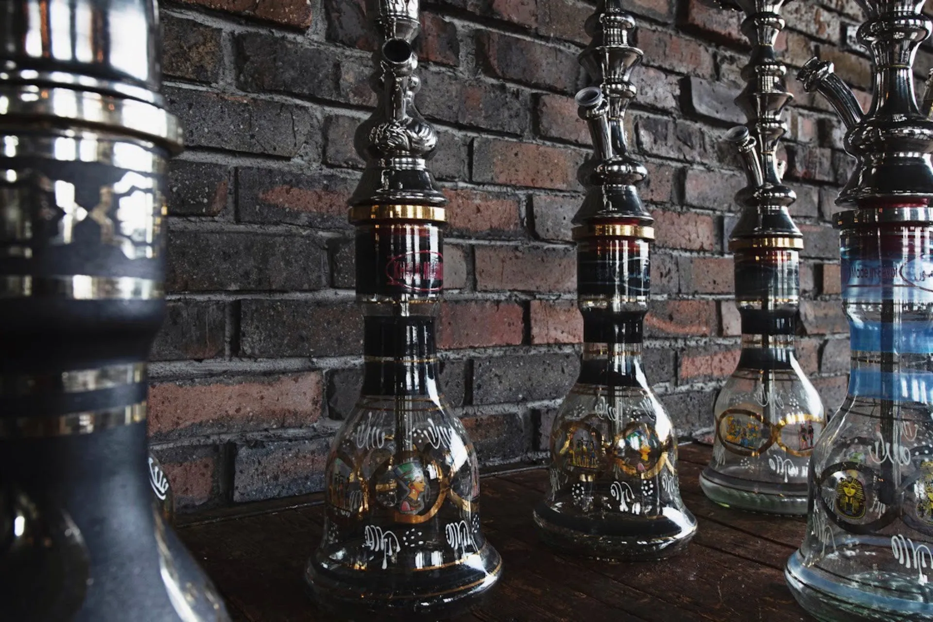 レンガの壁の前に並んだ複数のシーシャボトルのクローズアップ