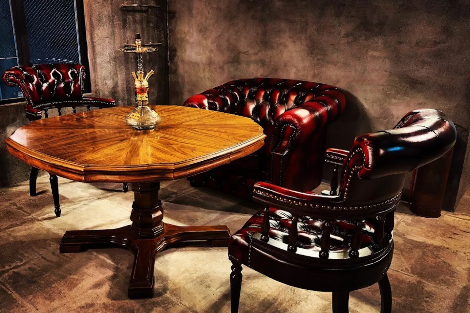 木製のテーブルと革張りの椅子が置かれた、落ち着いた雰囲気の部屋の写真