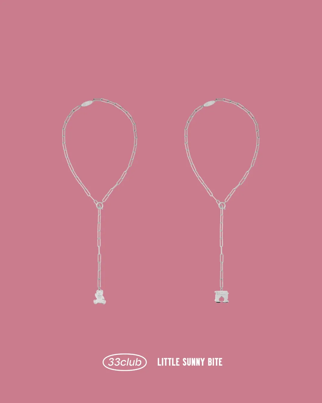ピンクの背景に、クマと家のような形をしたチャームが付いたシルバーネックレス。