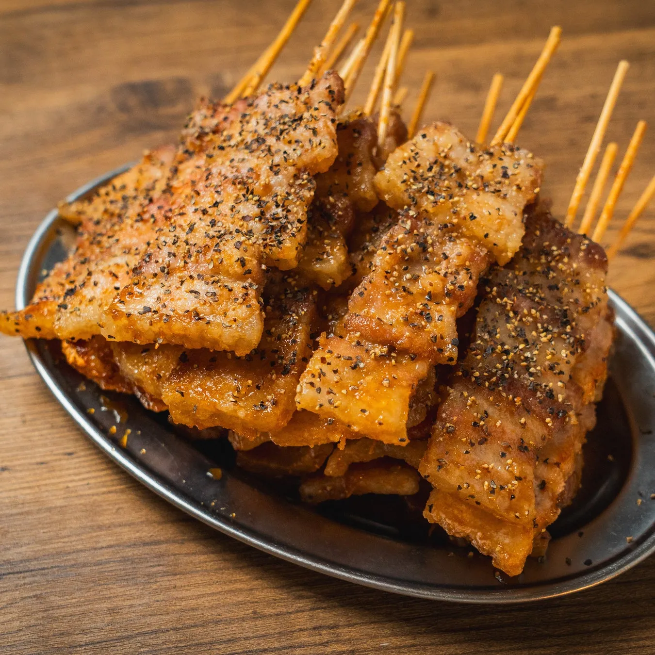 串焼きされた豚バラ肉の料理の写真