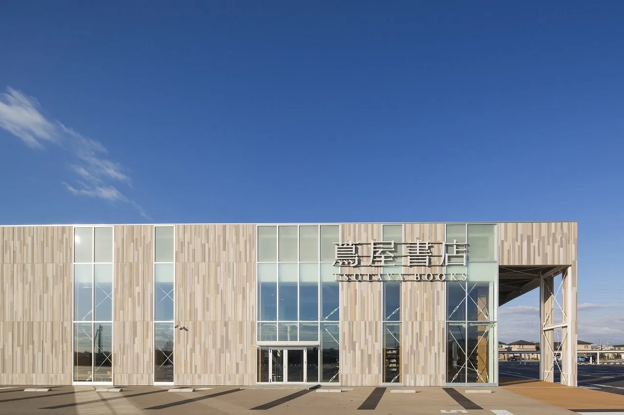 青空の下、蔦屋書店の外観を捉えた写真です。建物の外壁は木目調のデザインで、大きな窓が特徴的です。入り口にはTSUTAYA BOOKSの文字が大きく表示されています。