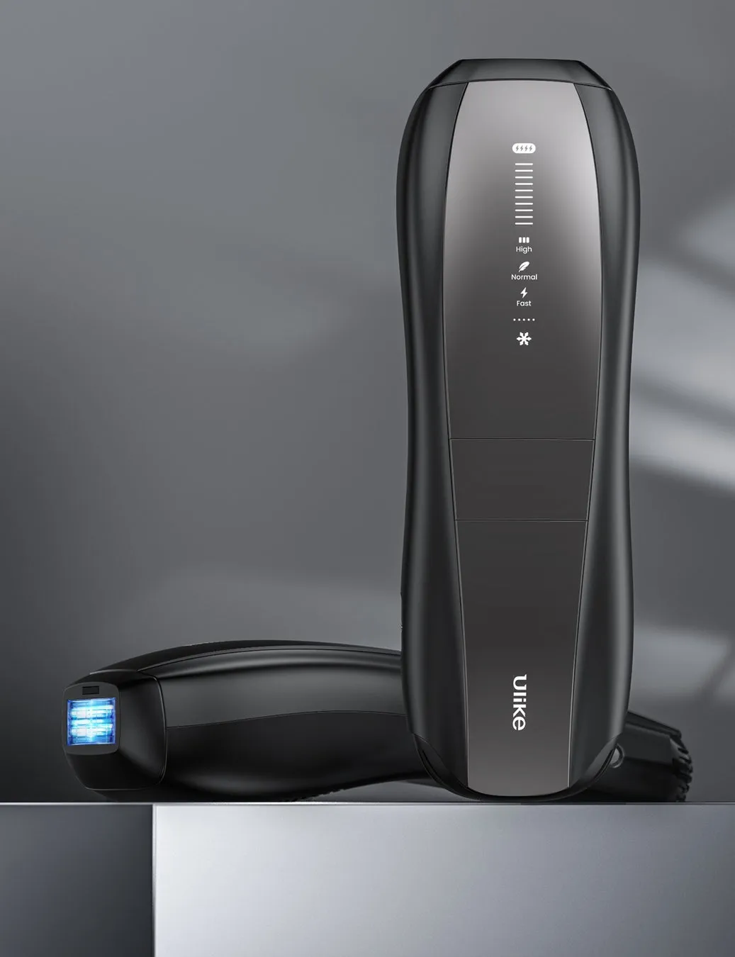 黒い美容機器が2つ並んで置かれている写真。一つは立っており、もう一つは横たわっている。機器にはLEDディスプレイがあり、機能が表示されている。