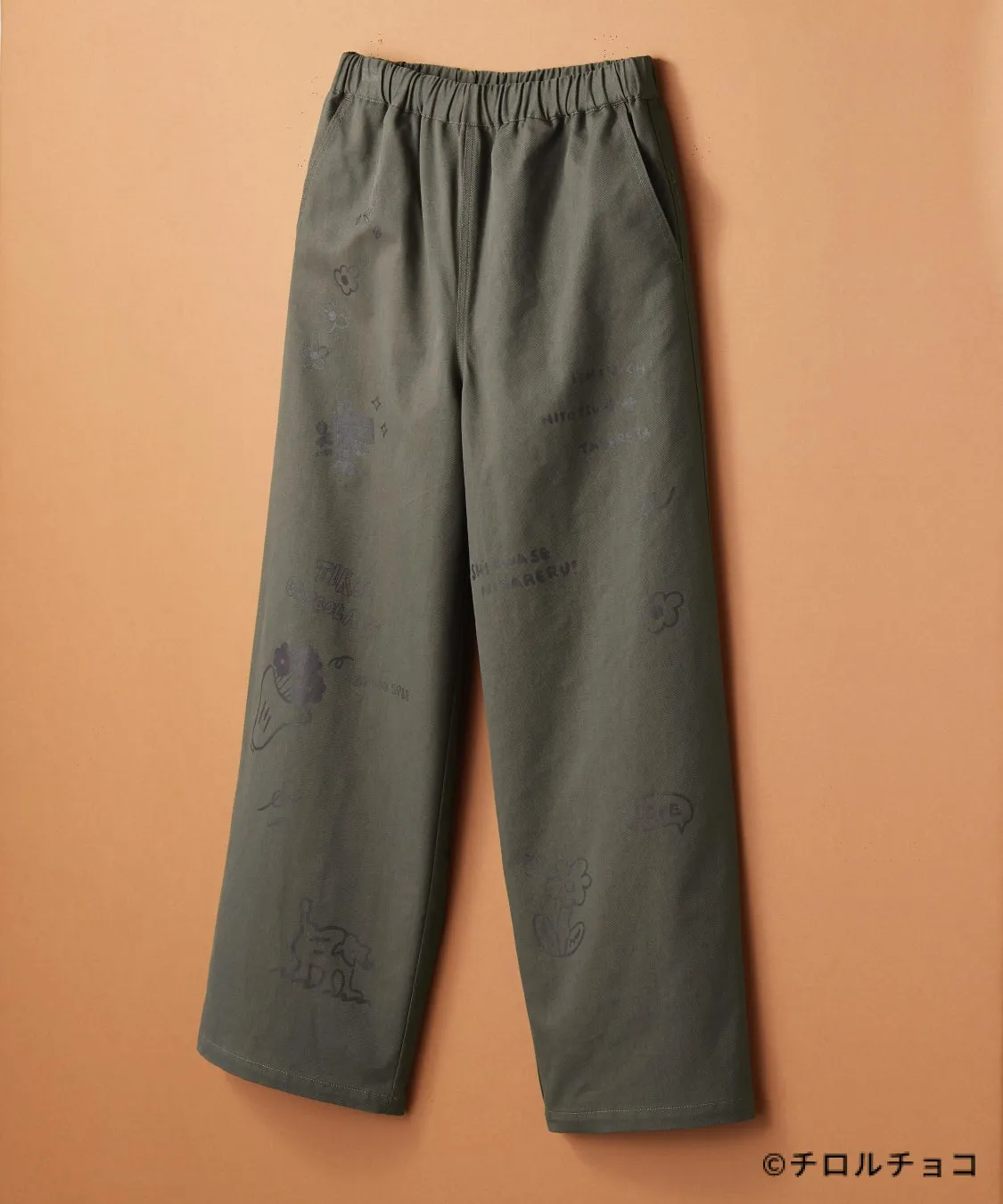カーキ色のパンツに、イラストと文字がプリントされています。