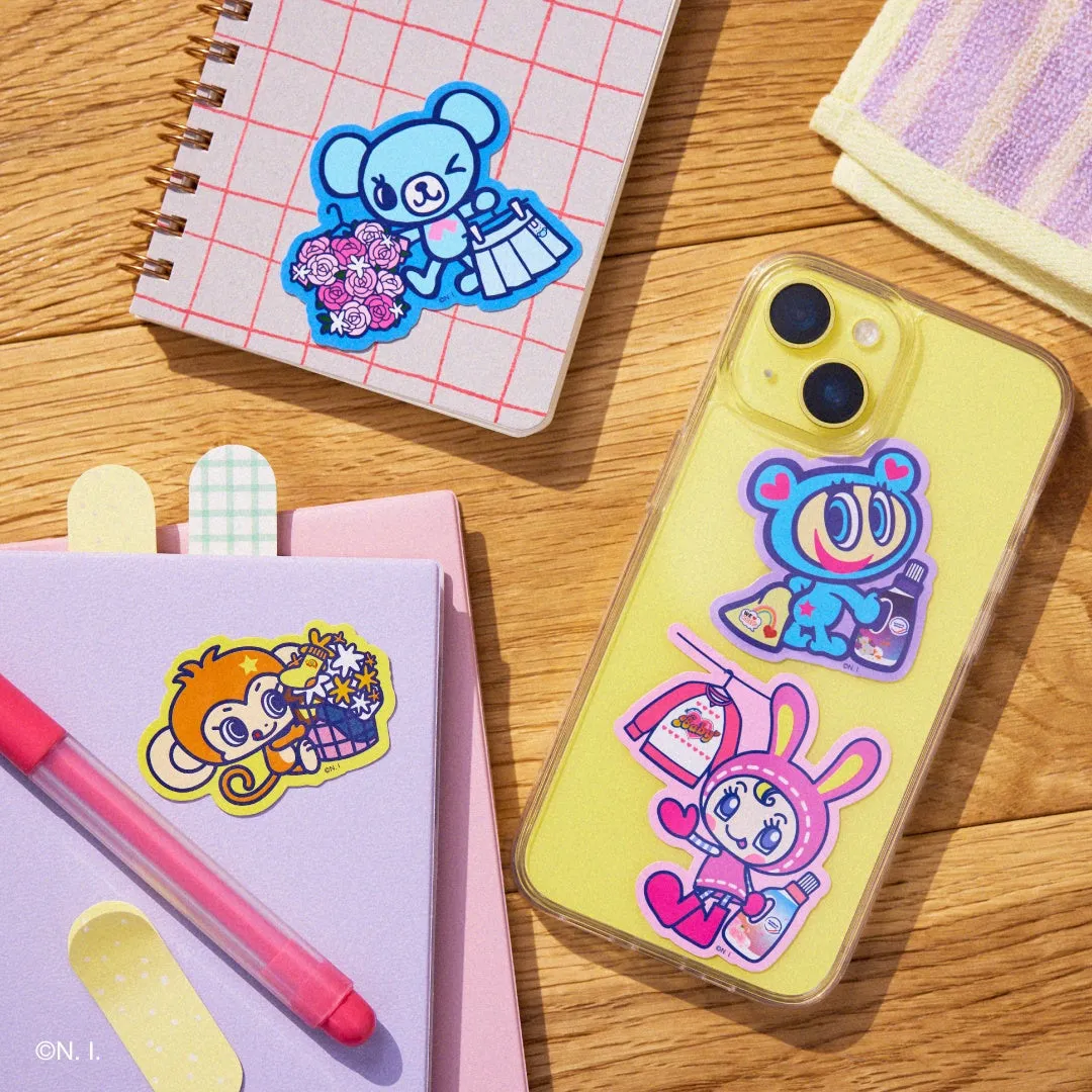 テーブルの上に、ノート、ペン、スマートフォン、ステッカーが置かれた写真