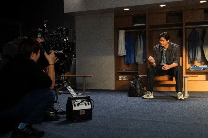 更衣室で野球ボールを手にカメラ撮影されている大谷翔平選手の写真です。