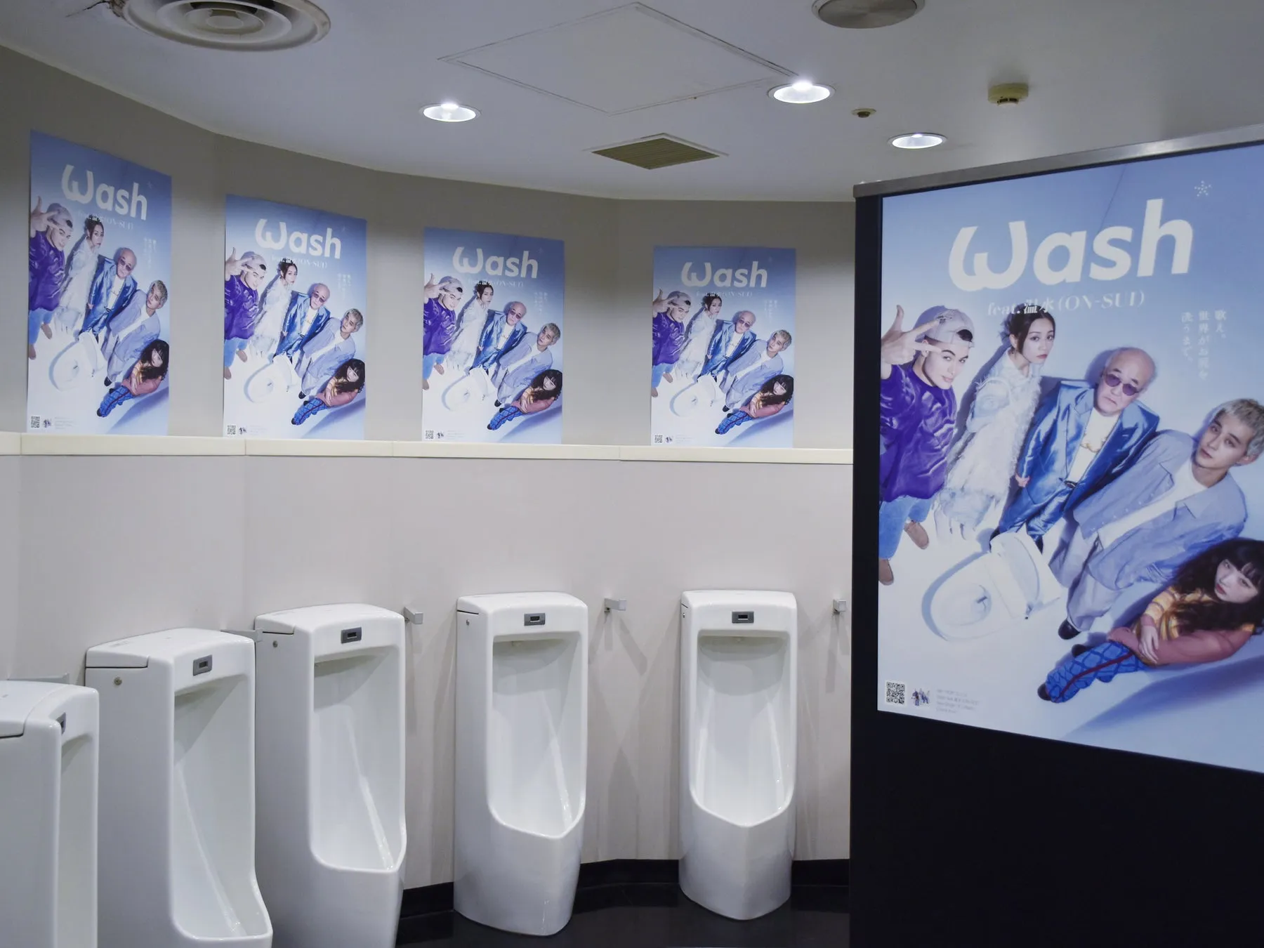 男子トイレの壁に貼られたWash feat.温水(ON-SUI)のプロモーションポスター。
