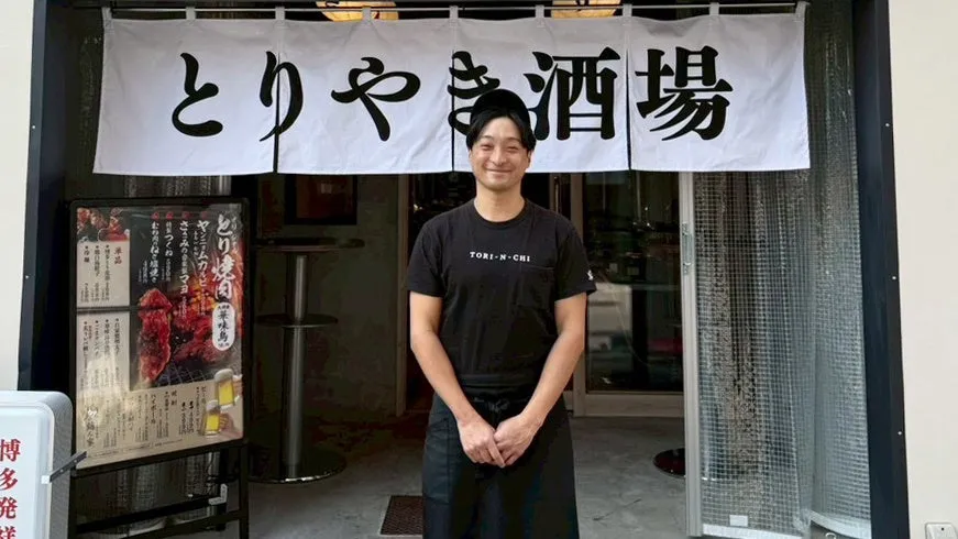 店の前で笑顔で立っている男性