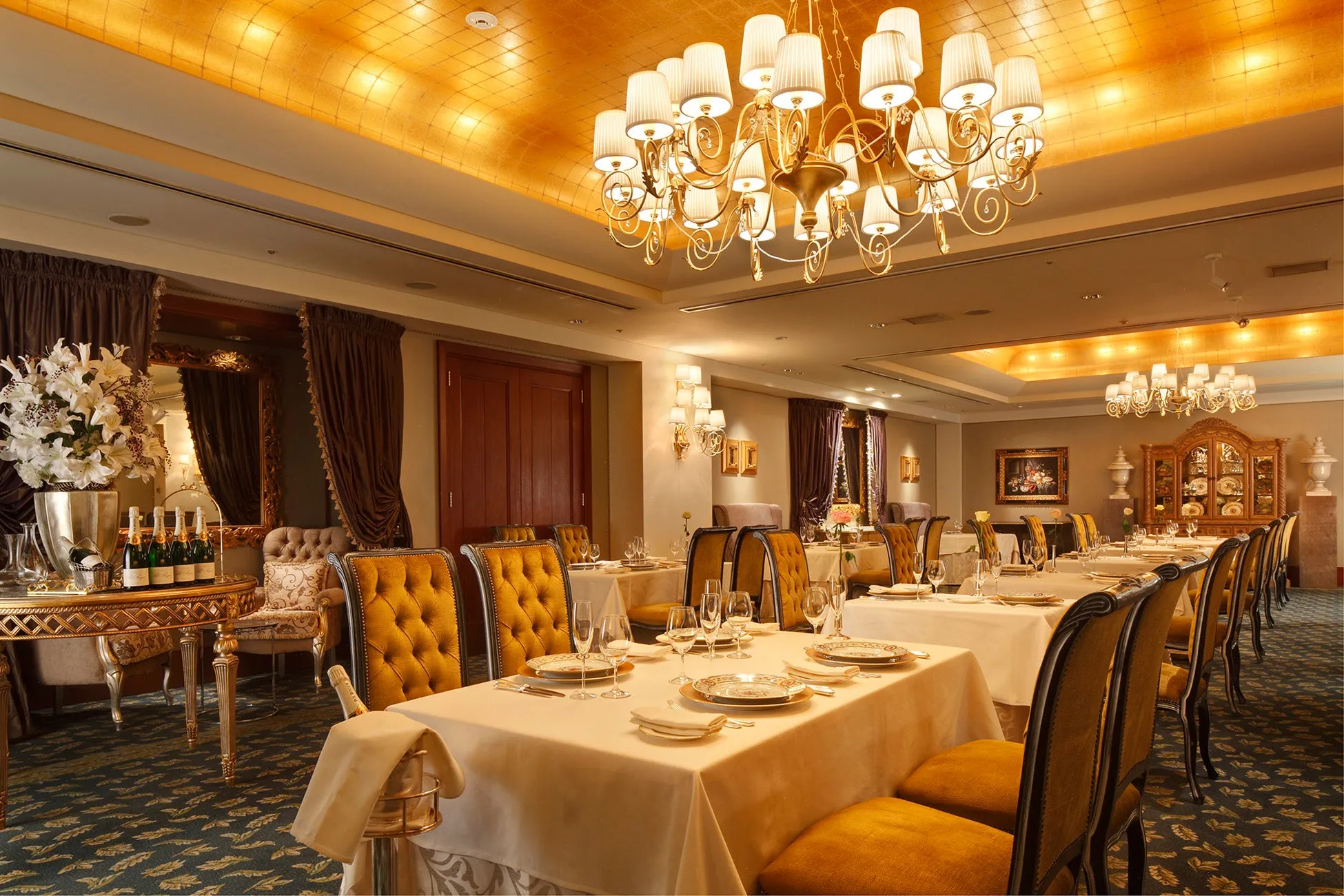 豪華なレストランのインテリア。テーブルセッティングが整い、シャンデリアが輝いています。