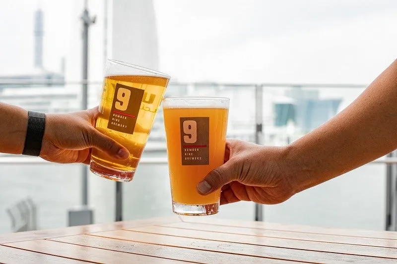 2つのビールグラスが乾杯している様子が写っています。