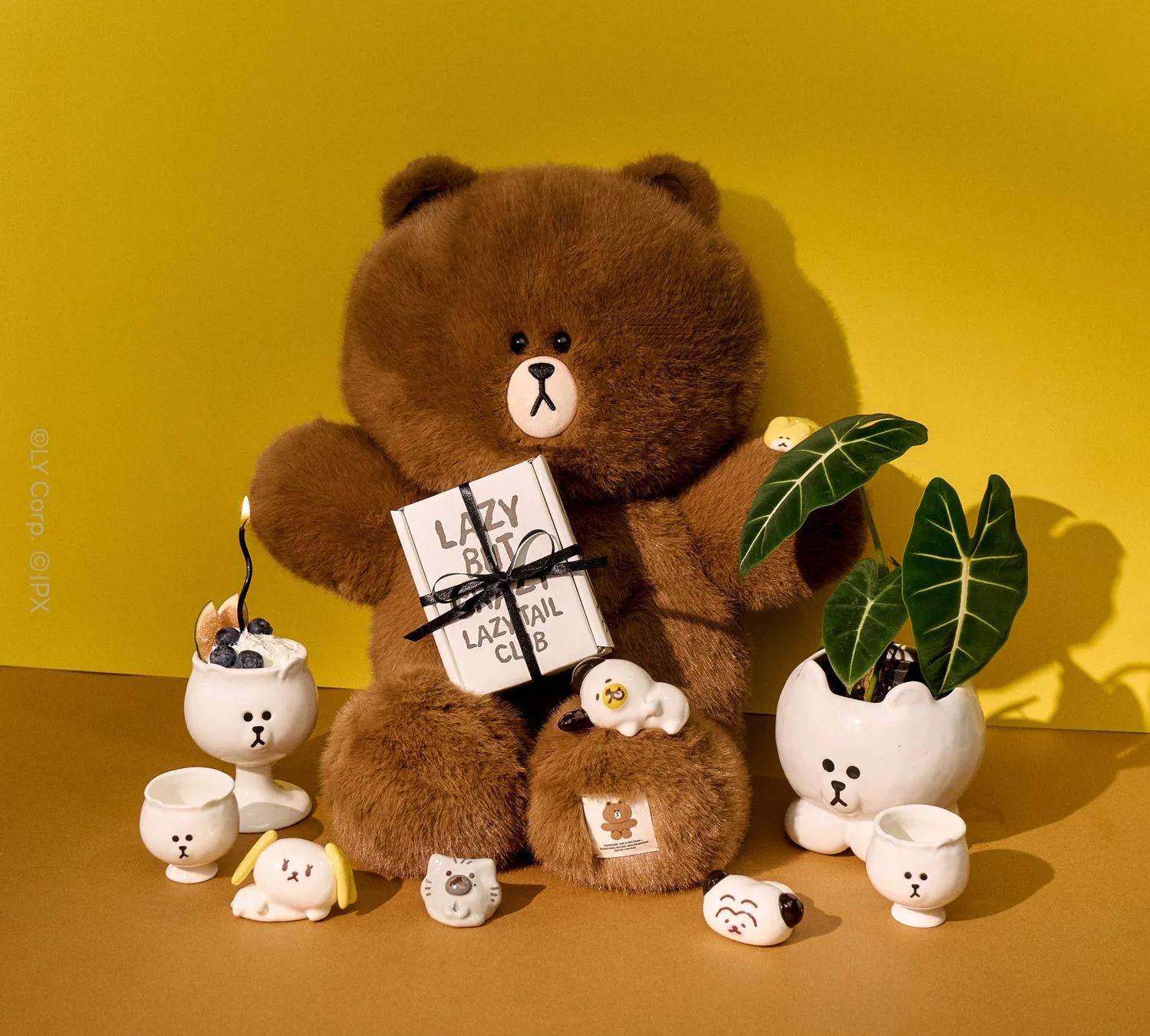 陶器のクマ、植物、プレゼントボックスなどが配置された写真