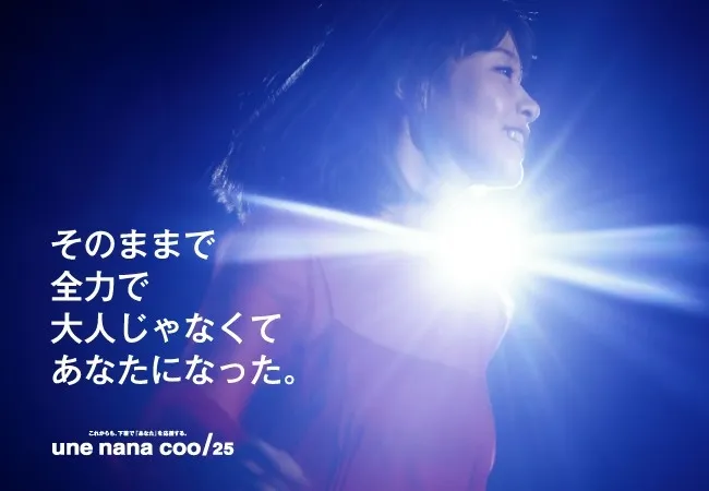 女性が明るい光の中で微笑んでいる広告。彼女の顔の横には、日本語で書かれたテキストが配置されています。