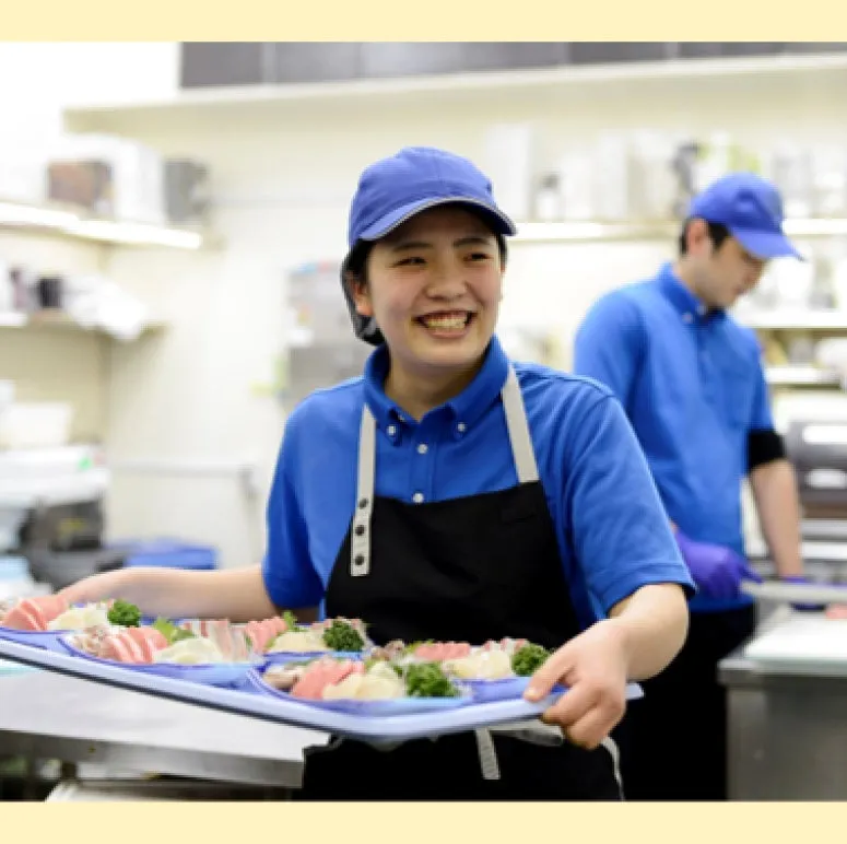 笑顔で料理を運ぶ女性の画像