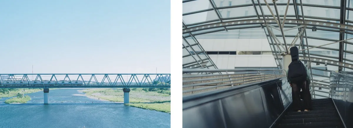 橋を渡る電車とエスカレーターに乗る人