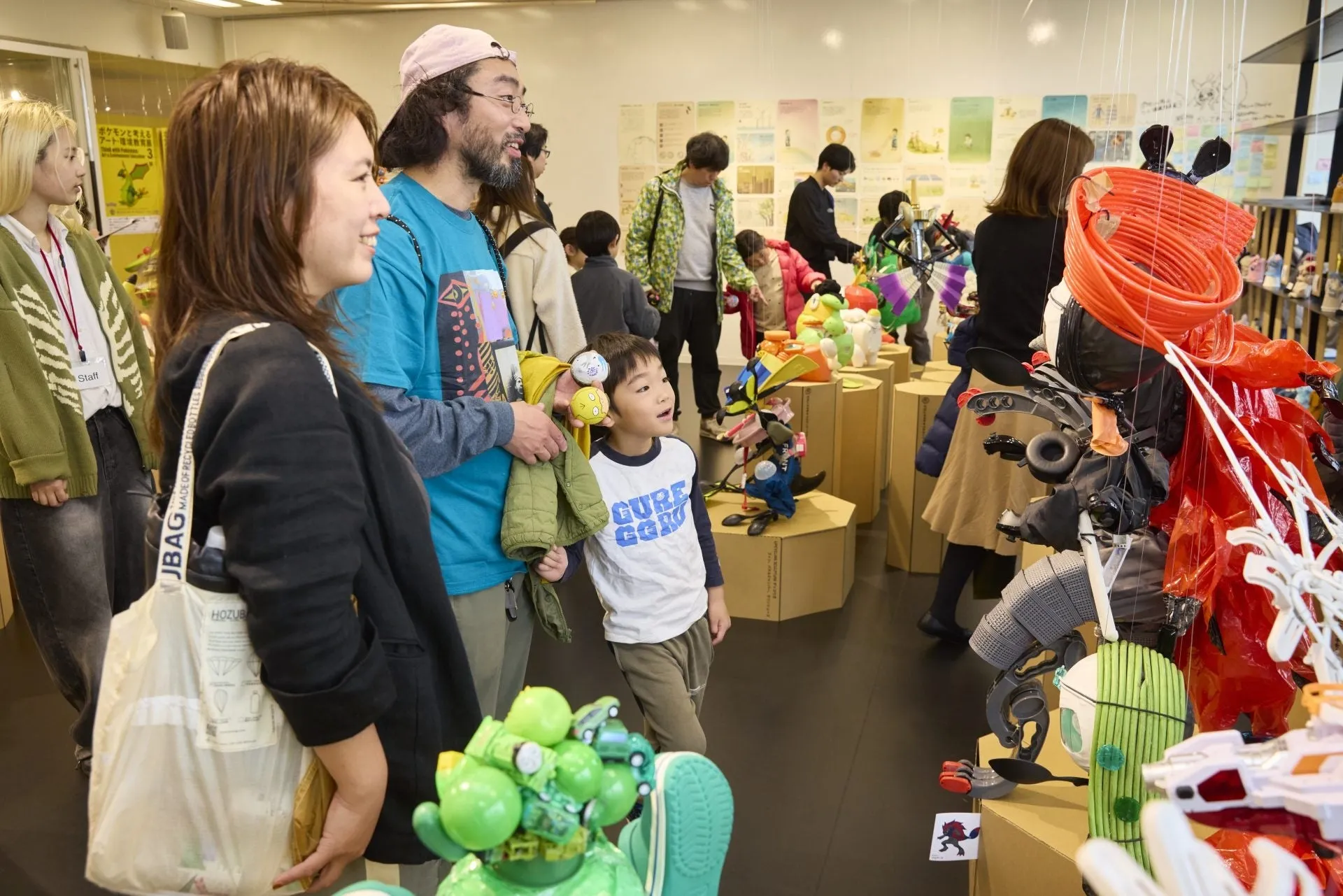 アート展で作品を見学する家族連れの様子。