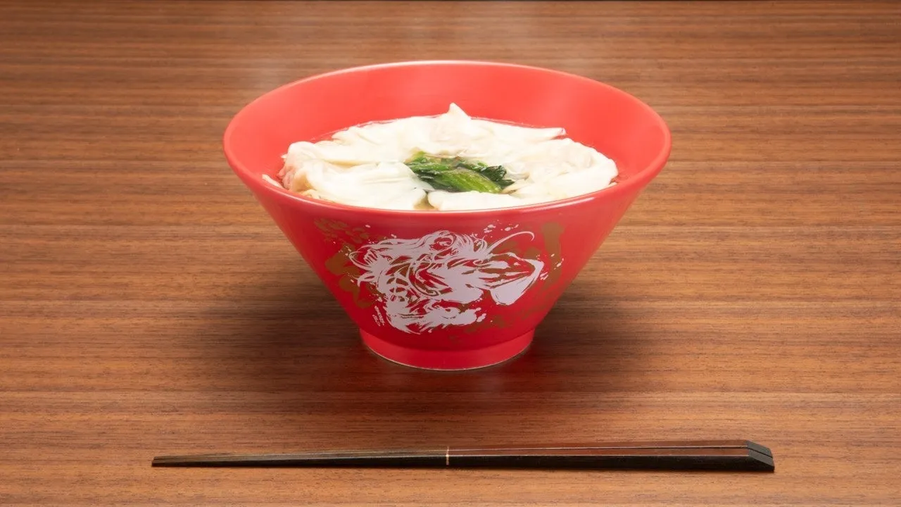 赤い丼に入った麺料理。箸が添えられている。