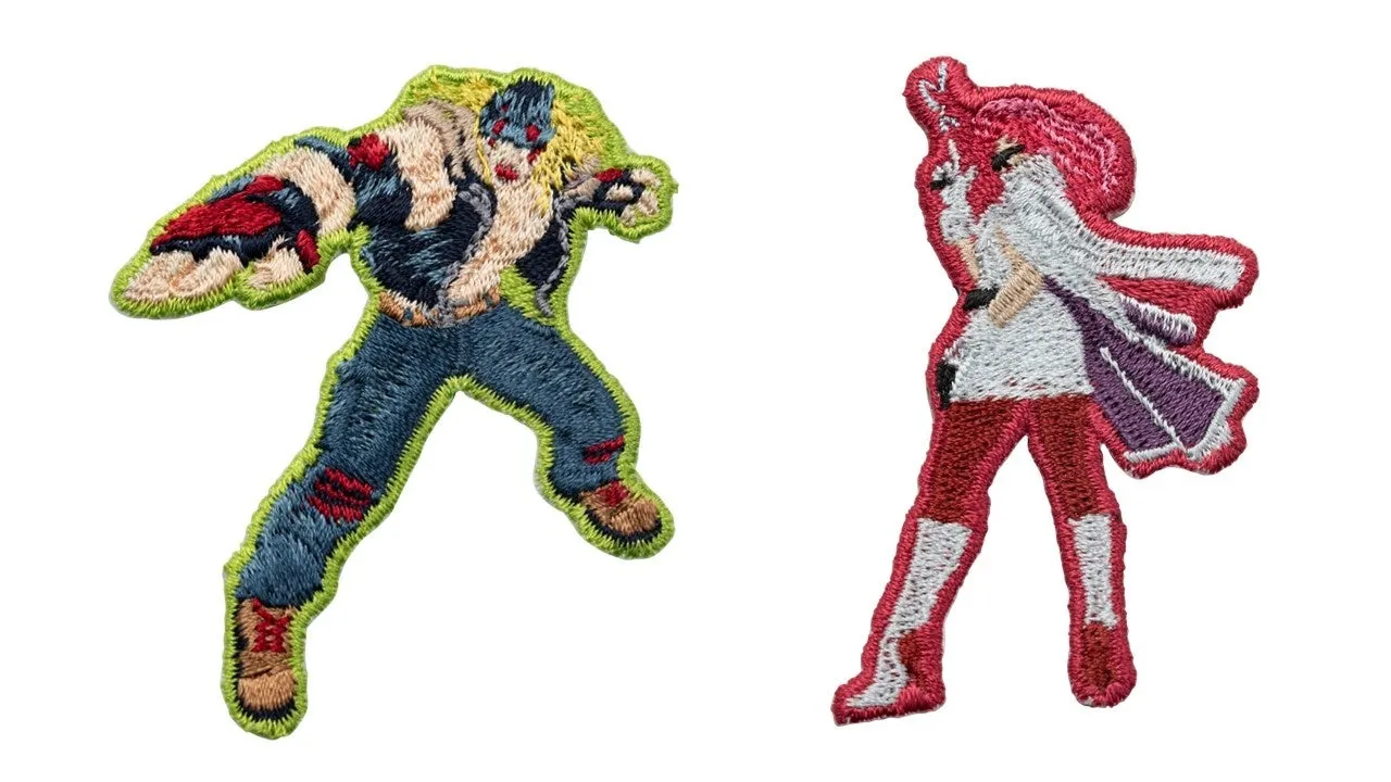 2人のキャラクターの刺繍パッチの画像。1人は青いズボンと赤い腕と肩にいる男性で、もう1人は赤い服を着た女性です。