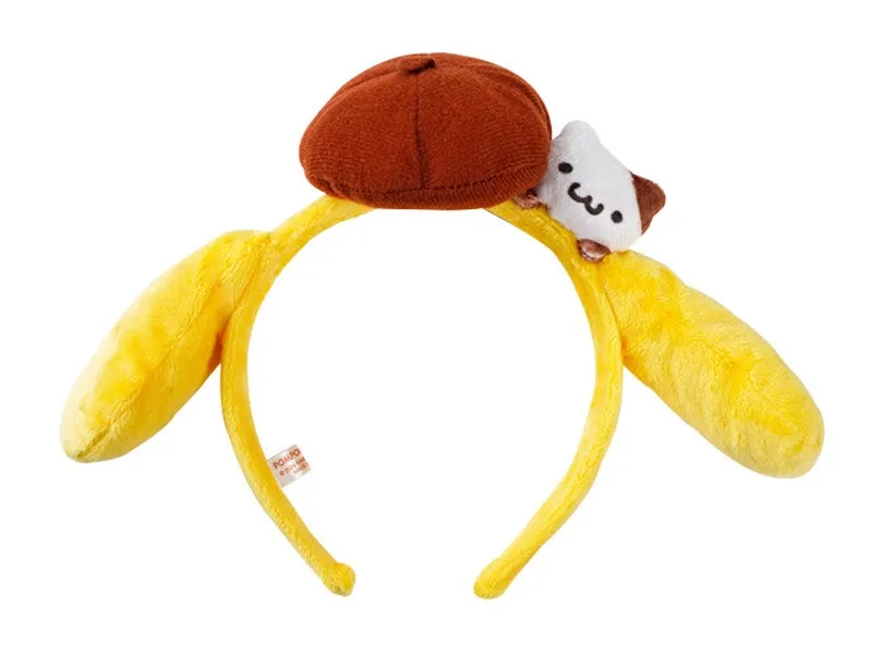 黄色いバナナの形をしたカチューシャ。茶色の帽子と白いキャラクターがカチューシャの上に配置されている。