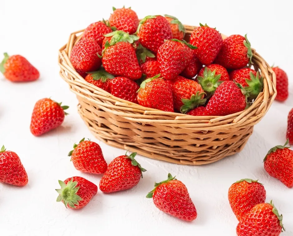 バスケットに入ったイチゴの写真です。バスケットの外にもイチゴが散らばっています。