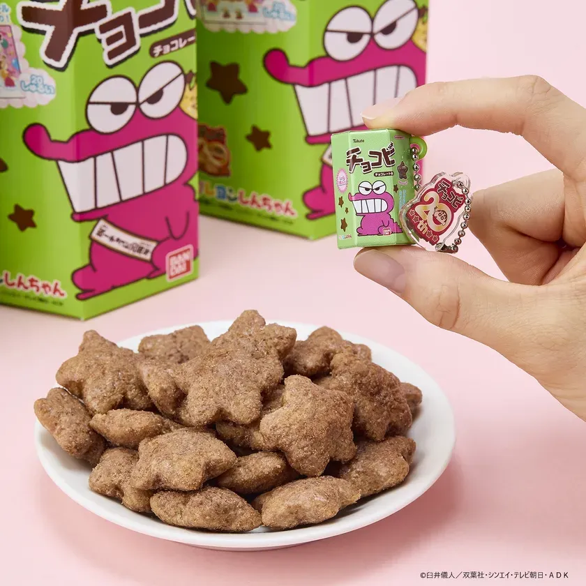 クレヨンしんちゃんのキャラクターが描かれたお菓子の写真です。星形のチョコビと、ミニチュアのチョコビのキーホルダーが写っています。