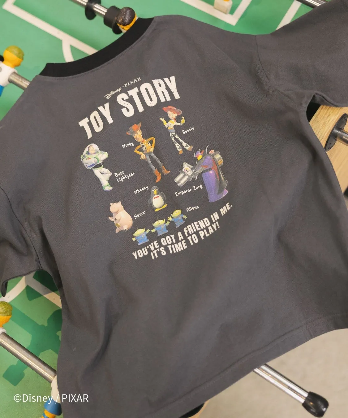 トイストーリーのキャラクターが描かれたTシャツの写真です。ウッディ、バズ・ライトイヤー、ジェシー、ハム、エイリアン、皇帝ザーグ、ウィージーが描かれています。「YOU'VE GOT A FRIEND IN ME. IT'S TIME TO PLAY!」の文字が入っています。