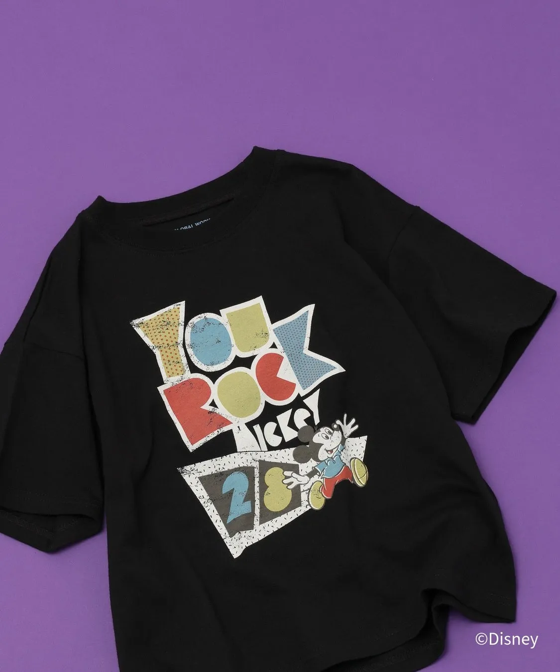 黒いTシャツにミッキーマウスのプリントが施されています。「YOU ROCK MICKEY 28」の文字とミッキーマウスのイラストが描かれています。Tシャツの右下には©Disneyの文字があります。