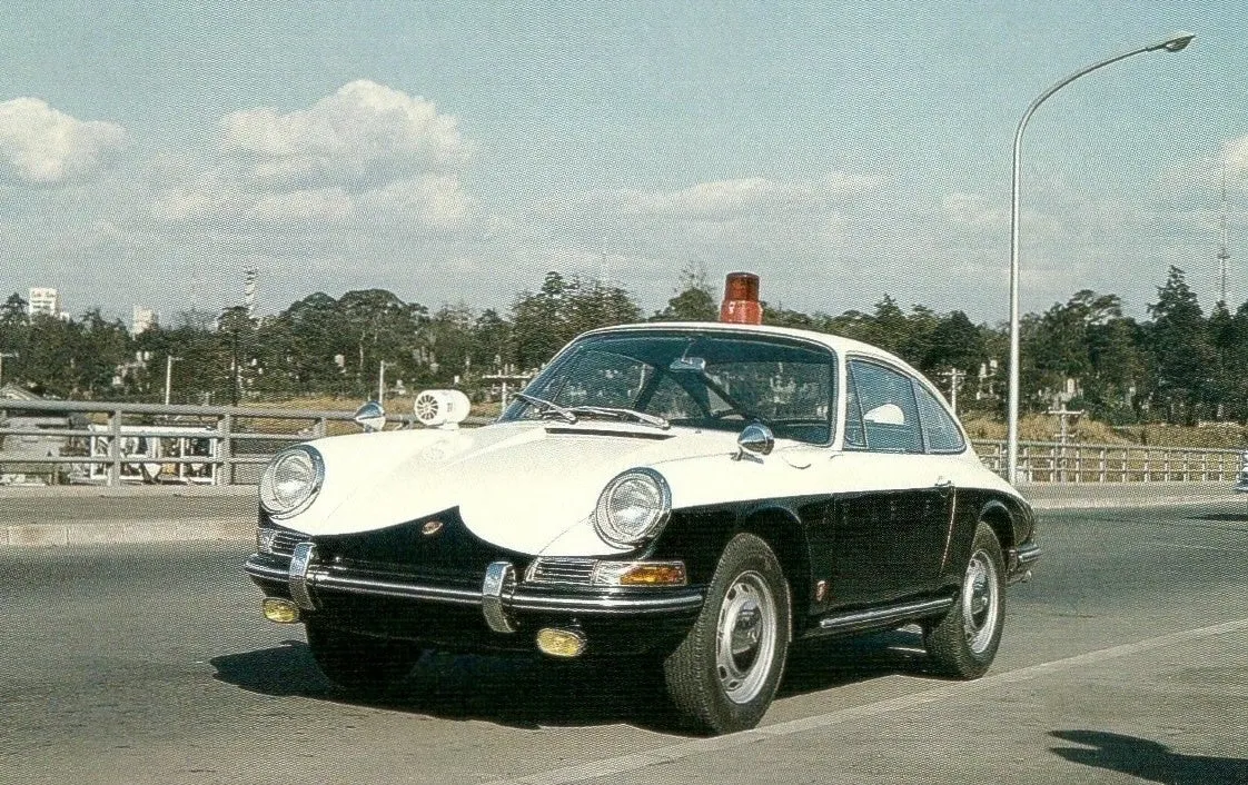 レトロなパトカーの画像。白黒のツートンカラーで、赤色のサイレンと回転灯が特徴的。