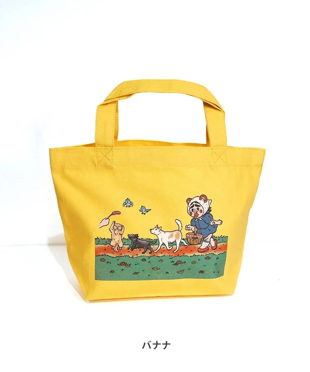 黄色いトートバッグ。前面には、犬と女の子が描かれたイラストがプリントされている。バッグの下には「バナナ」の文字。