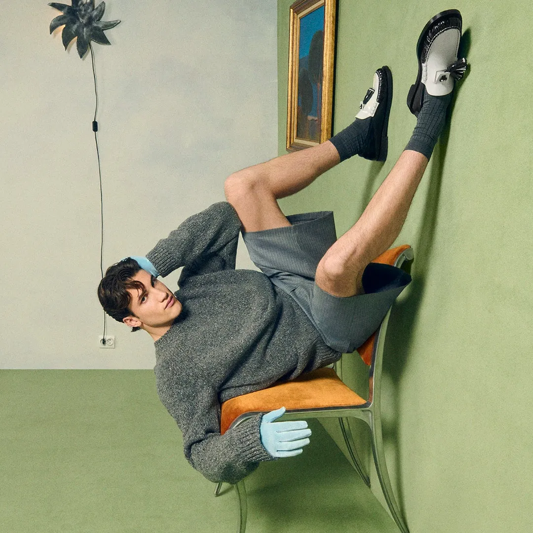 男性が椅子に座り、壁にもたれ掛かっている写真