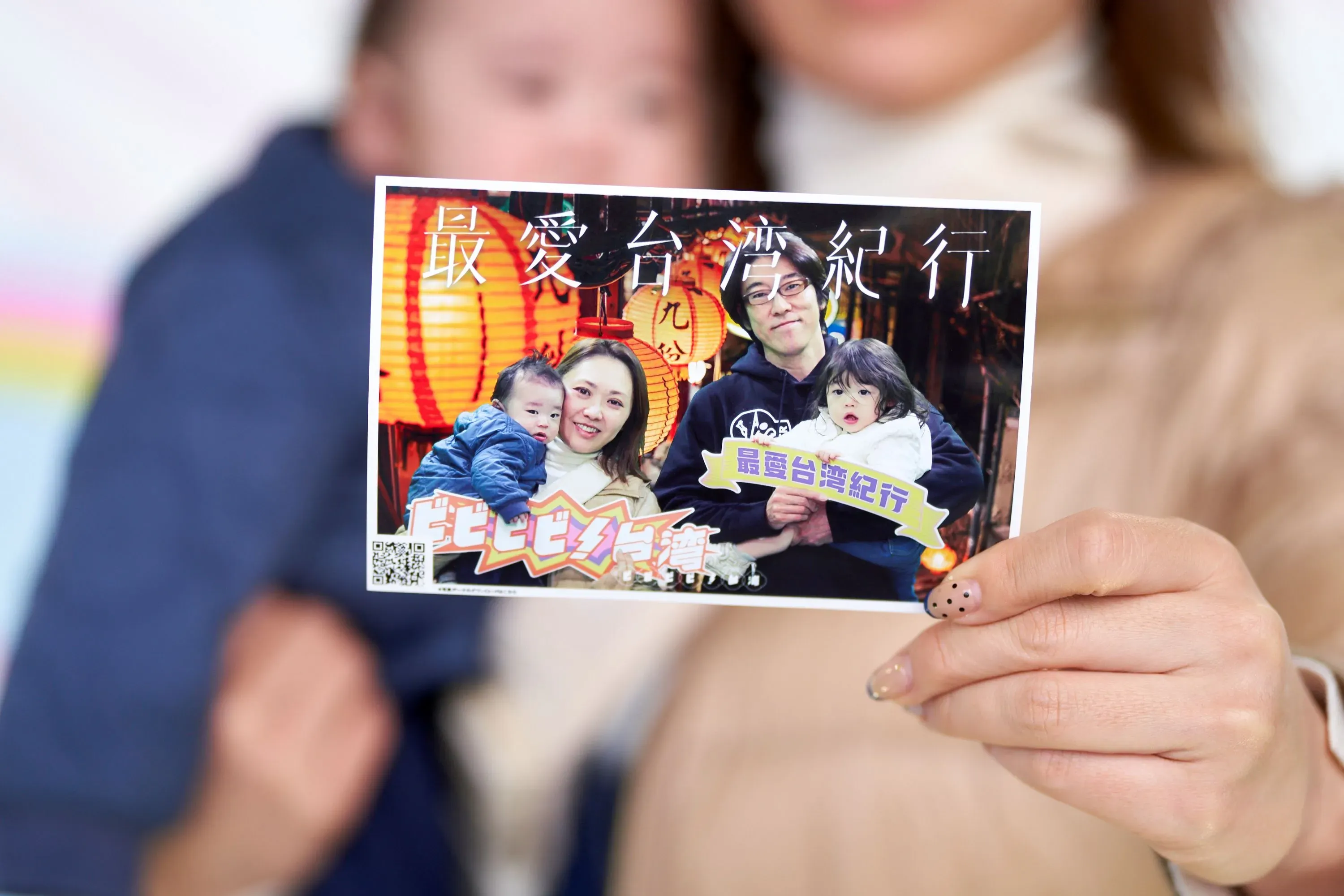 女性が家族の写真を持つ様子。