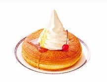 ドーナツの上にソフトクリームとサクランボが乗ったデザートの画像。