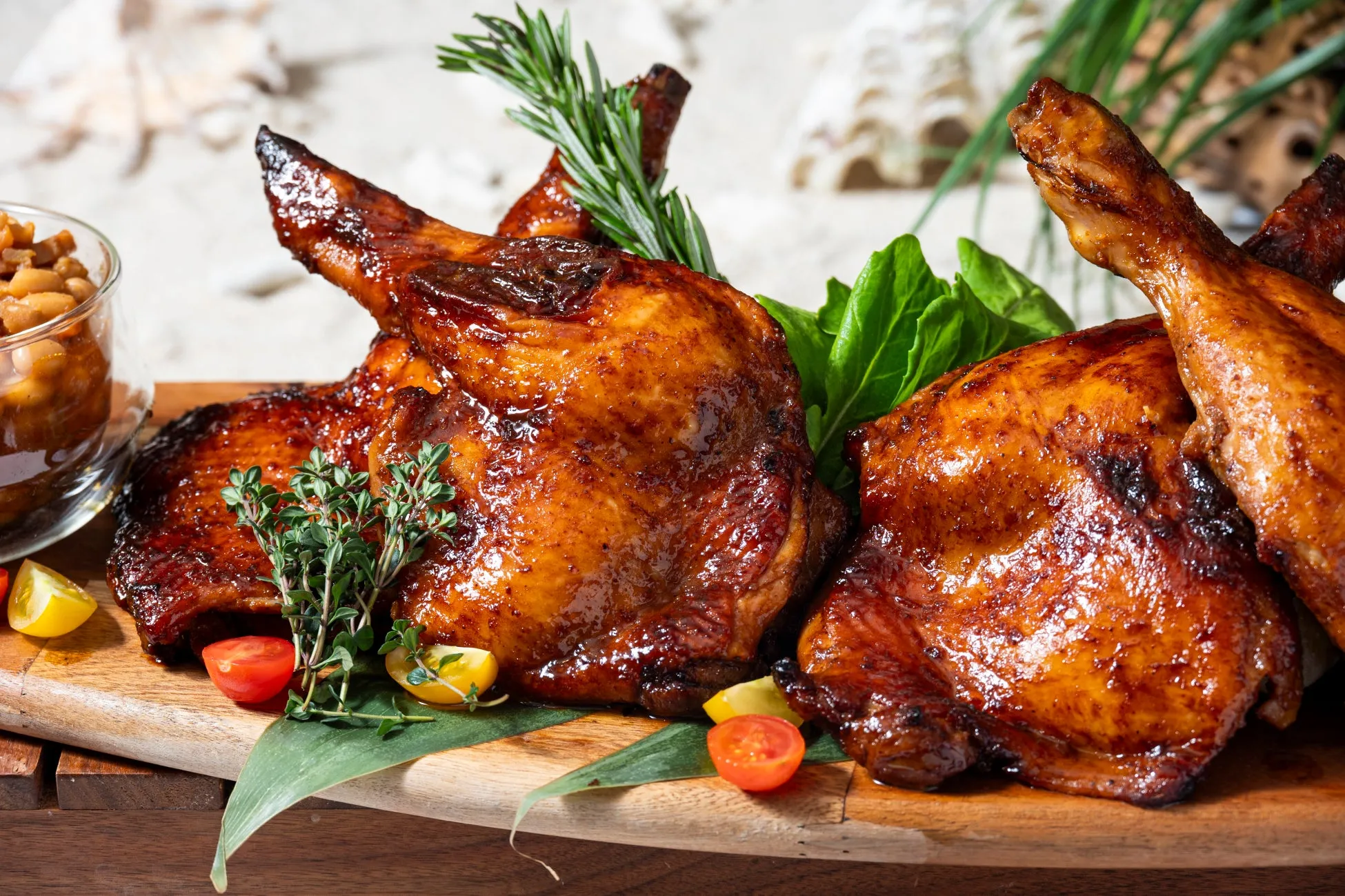 木製のまな板に盛られた、照り焼きチキンと付け合わせの料理