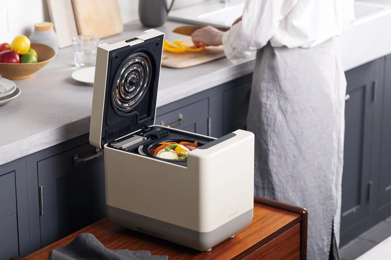 レコルトのロゴとキッチンで調理する女性