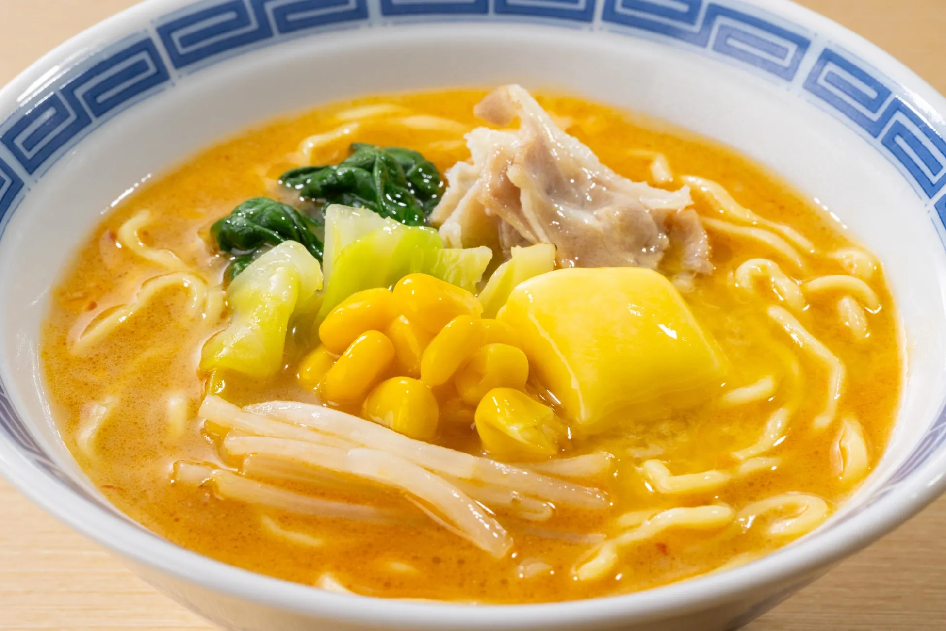 ラーメンのクローズアップ。麺、野菜、肉、スープが入った丼。