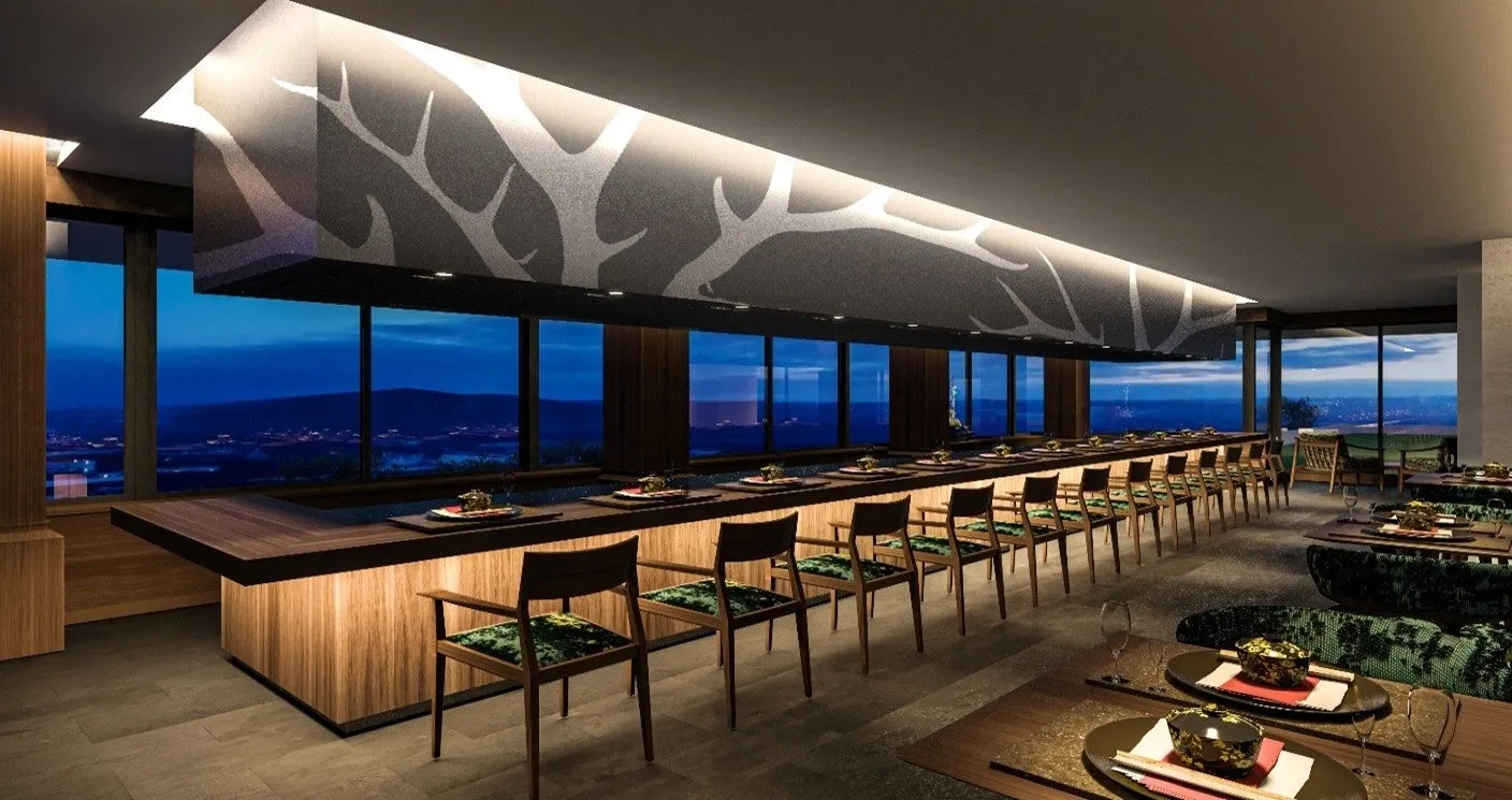 夜景を望む高級レストランのインテリア。長いカウンター席とテーブル席があり、落ち着いた雰囲気。