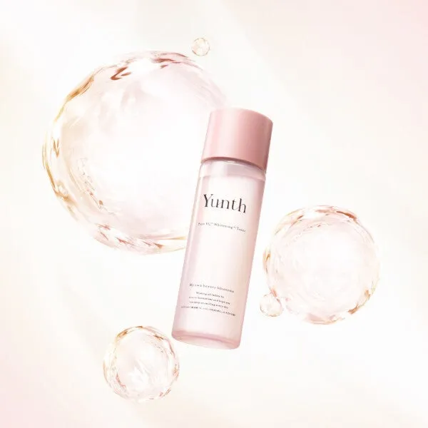 ピンク色のボトルに入った化粧水。周りには水の泡のようなものが配置されている。