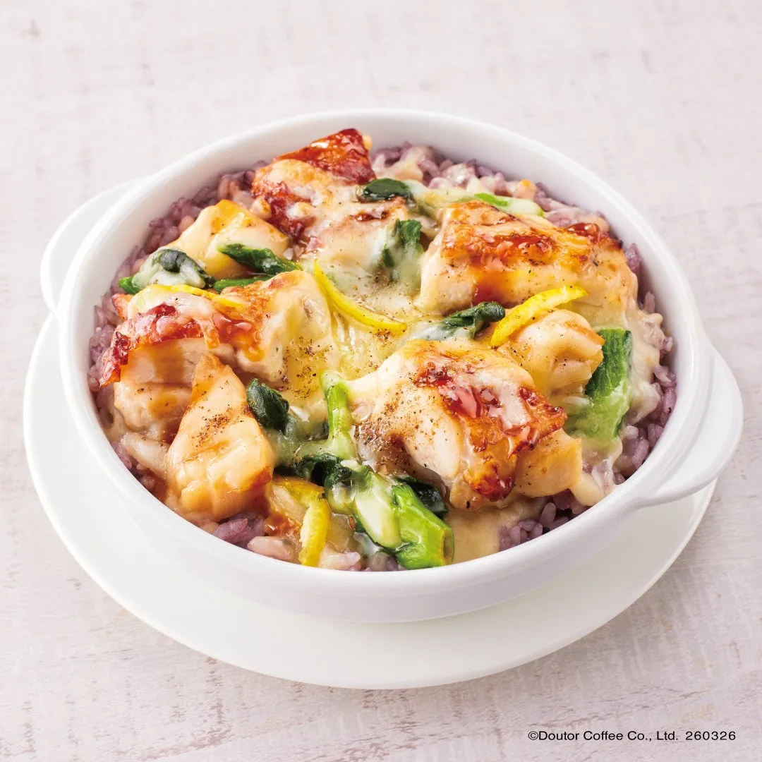 白い器に入った、紫米の上にチキンとチーズ、野菜が乗った料理の写真です。