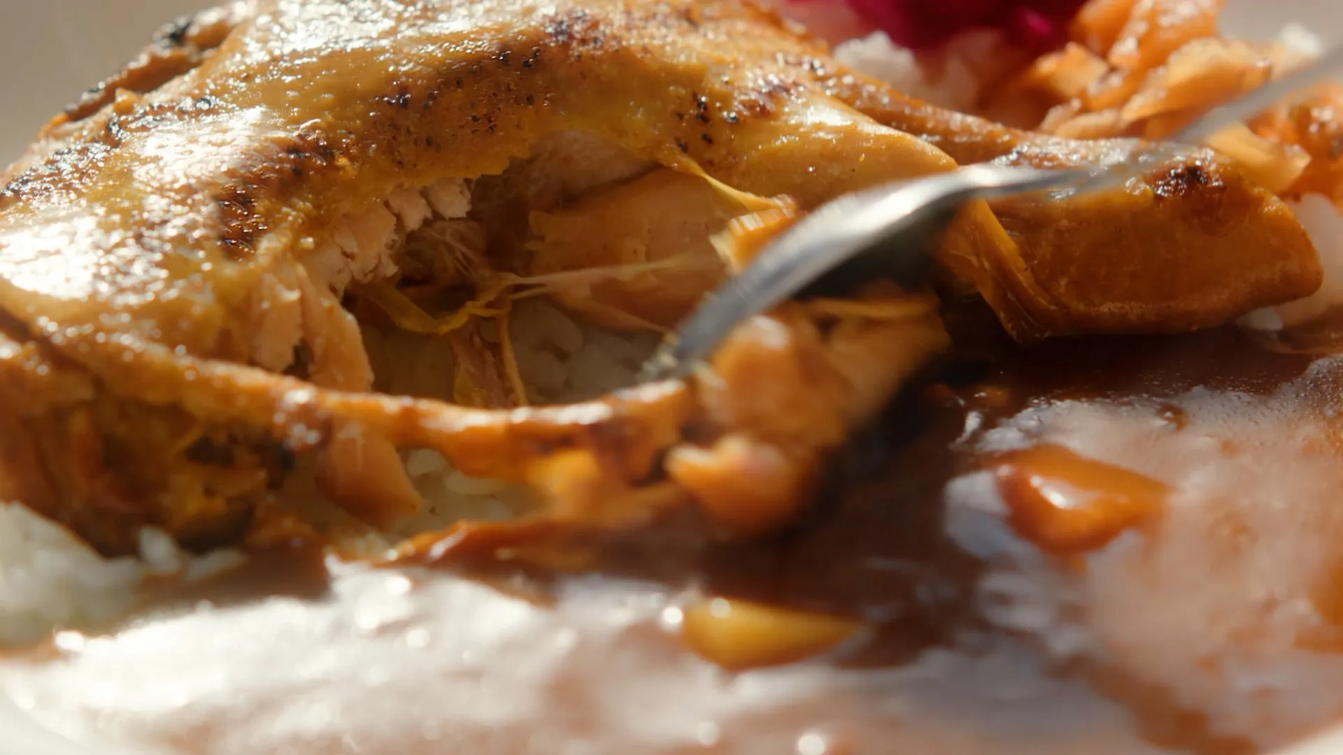 鶏肉とご飯、ソースを添えた料理のクローズアップ写真