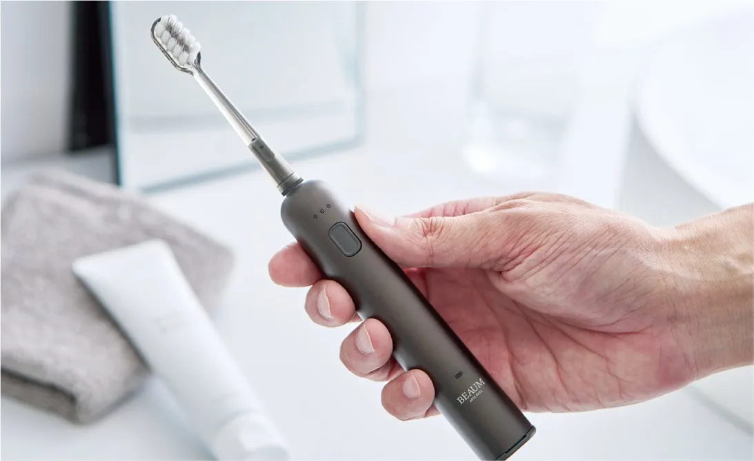 電動歯ブラシを持つ手