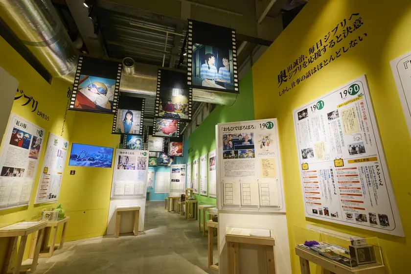 ジブリ作品の展示会場の様子。映画のシーンが展示され、壁には作品に関する情報が書かれています。