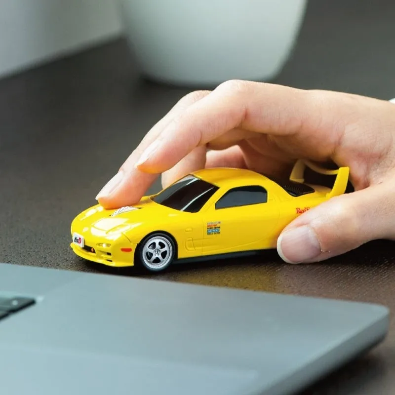 黄色い車型のマウスを手に持っている様子。